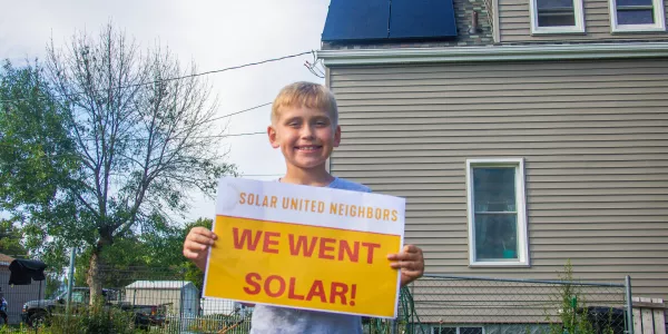 Photo of family in front of their new solar panels. 