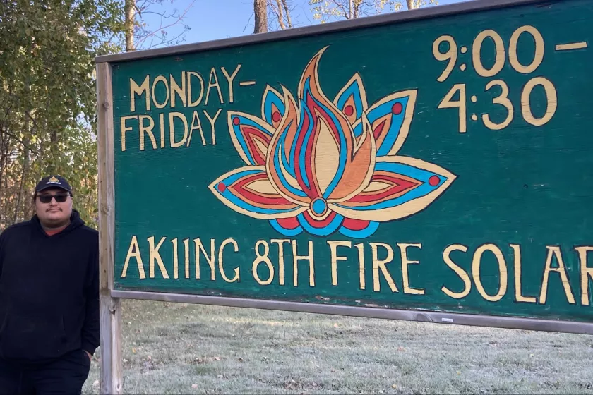 Gasco standing in front of 8th Fire Solar sign