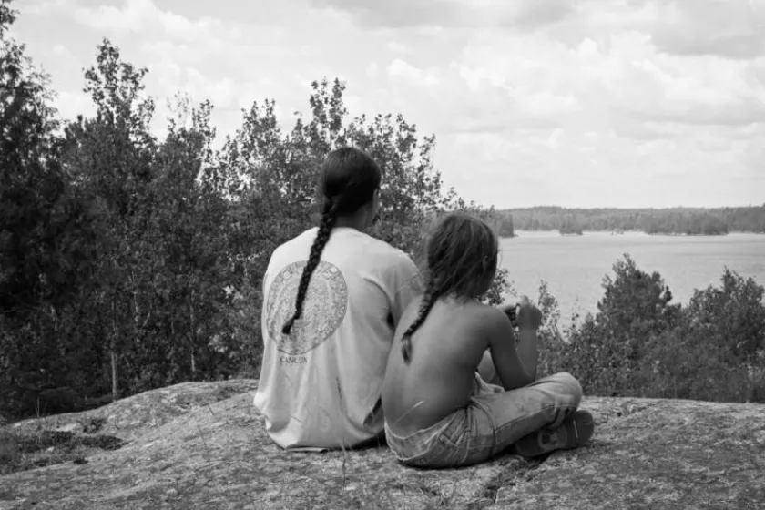 People sitting on a lake shore