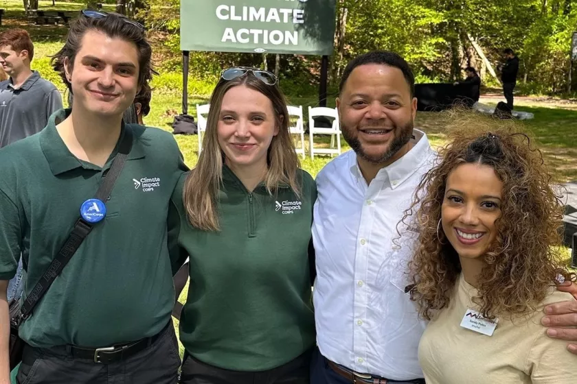 Rau stands outdoors with Michael Smith and two other AmeriCorps members, smiling.