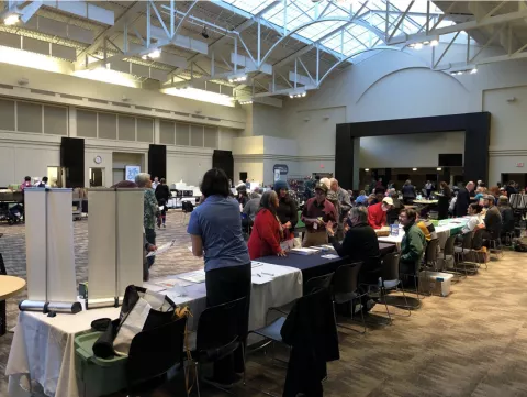 People gathering in a conference room with tables