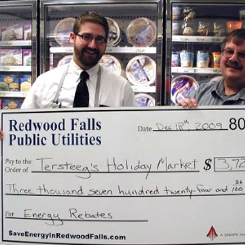 BJ Tersteeg receives a rebate from Chuck Heins, Superintendent of Redwood Falls Public Utilities