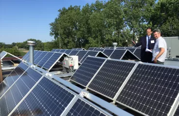 Mayor Peter Lindstrom shows off solar panels atop Falcon Heights City Hall