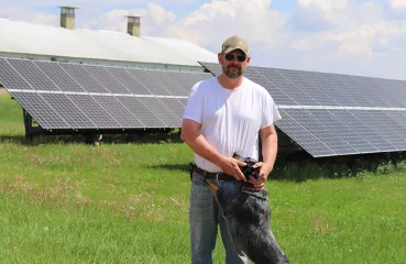 John and his dog by solar panels