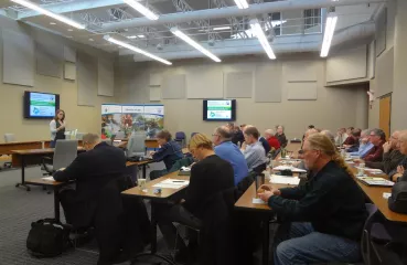 People sitting at tables watching a presentation