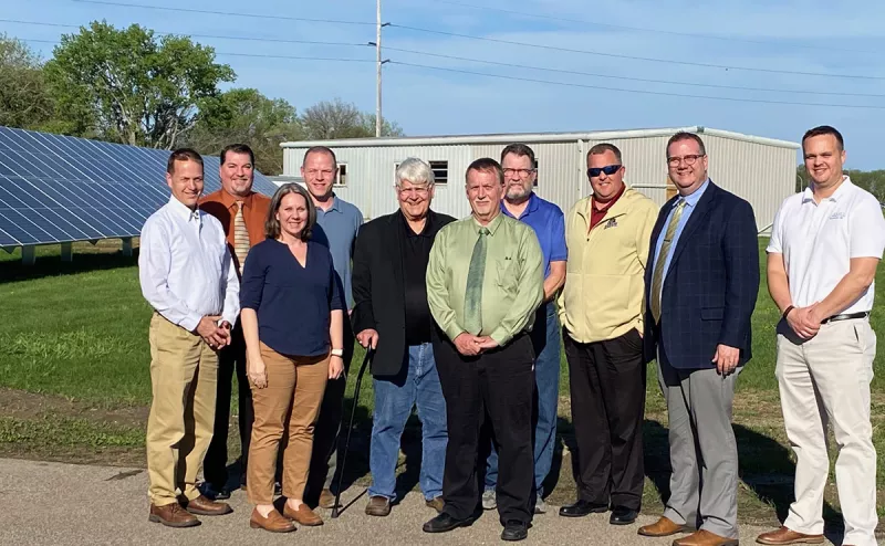 School board members and reps standing with solar array.